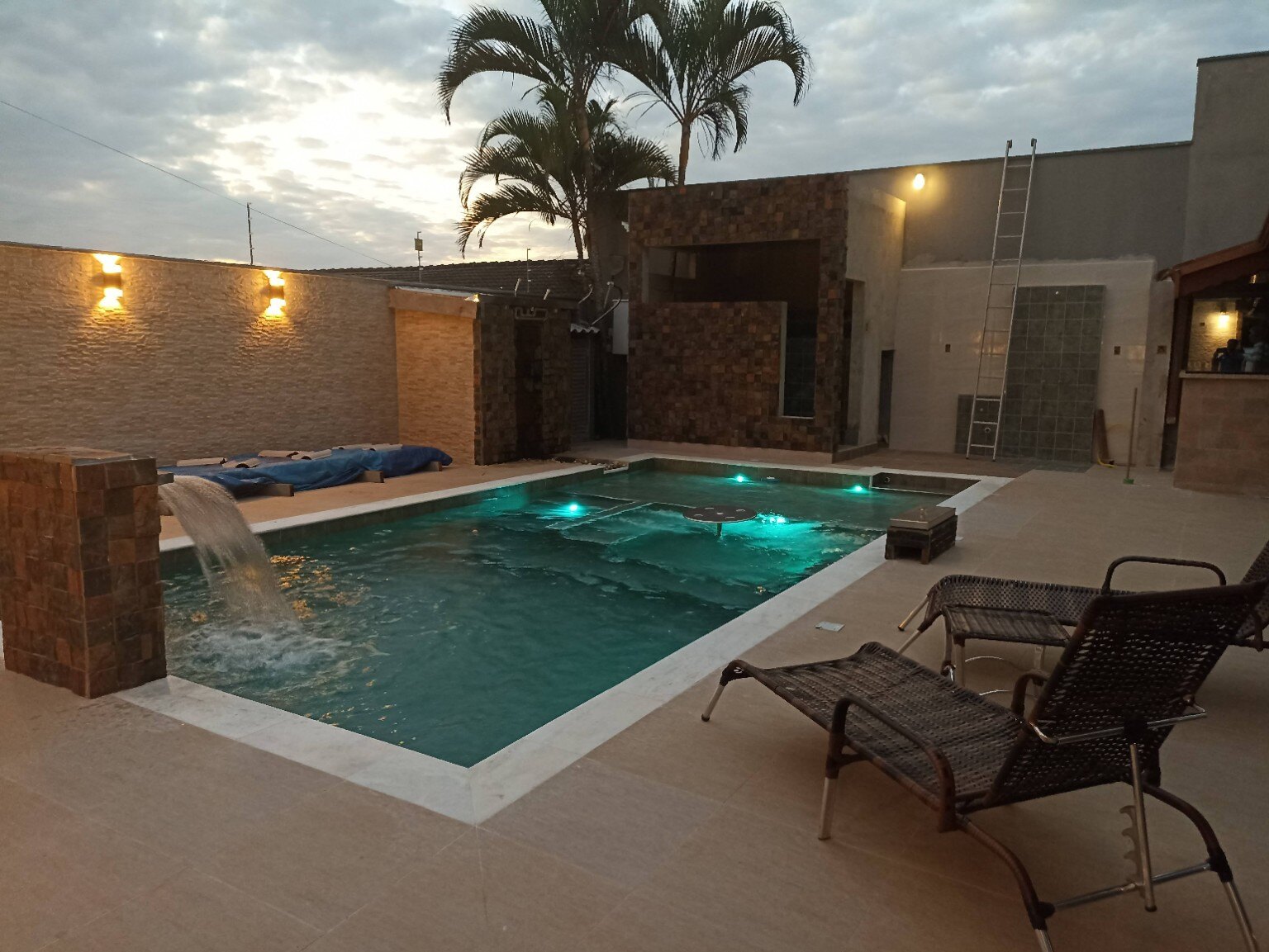 Piscina iluminada com cascata