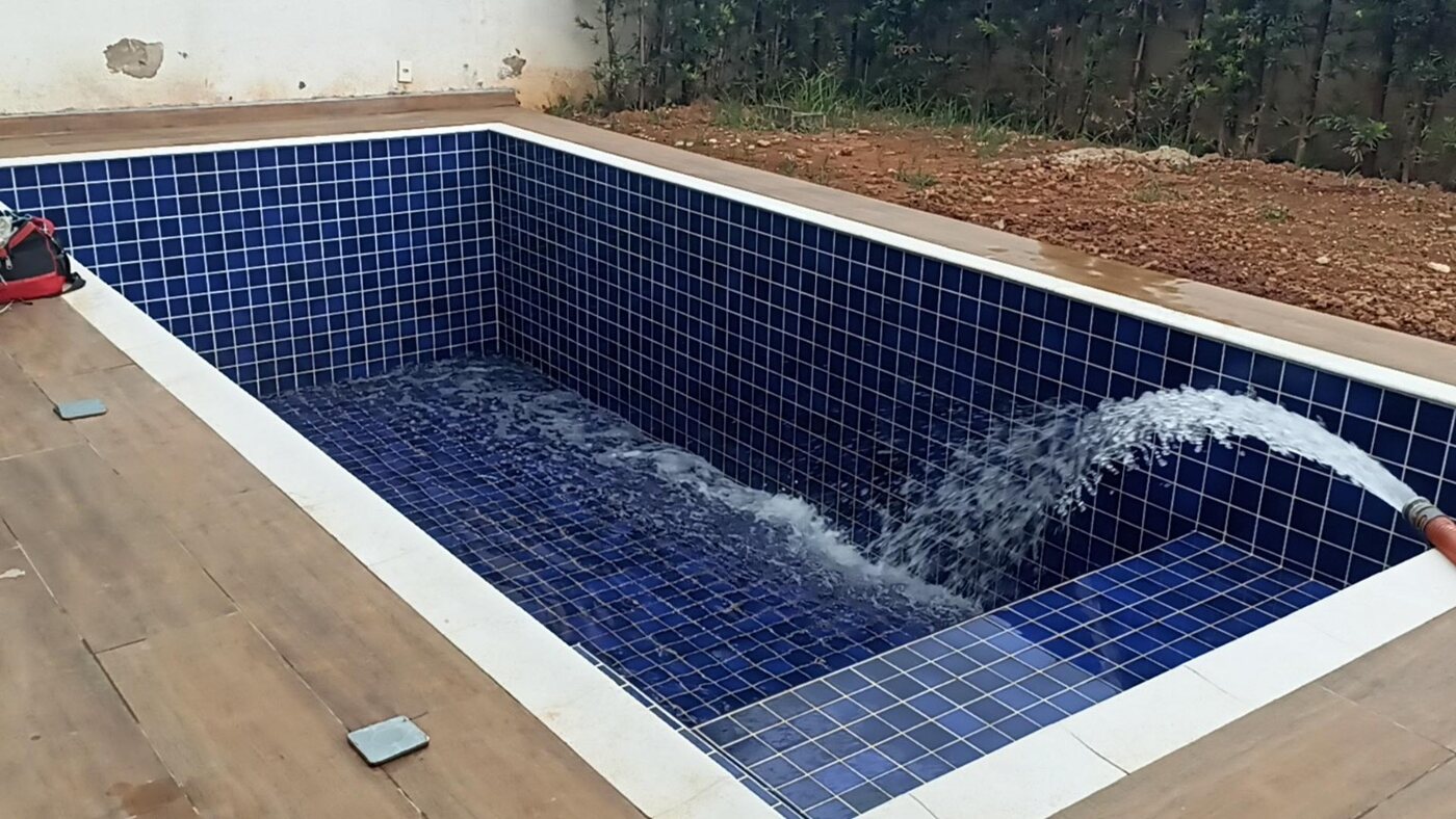 Piscina sendo abastecida por caminhão-pipa