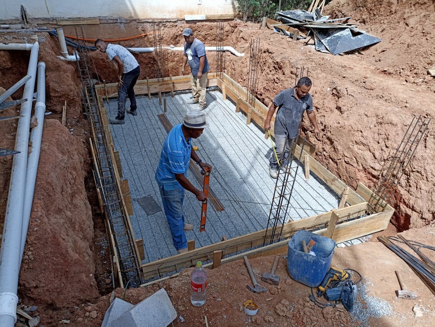 Equipe executando a estrutura e a infraestrutura hidráulica de uma piscina