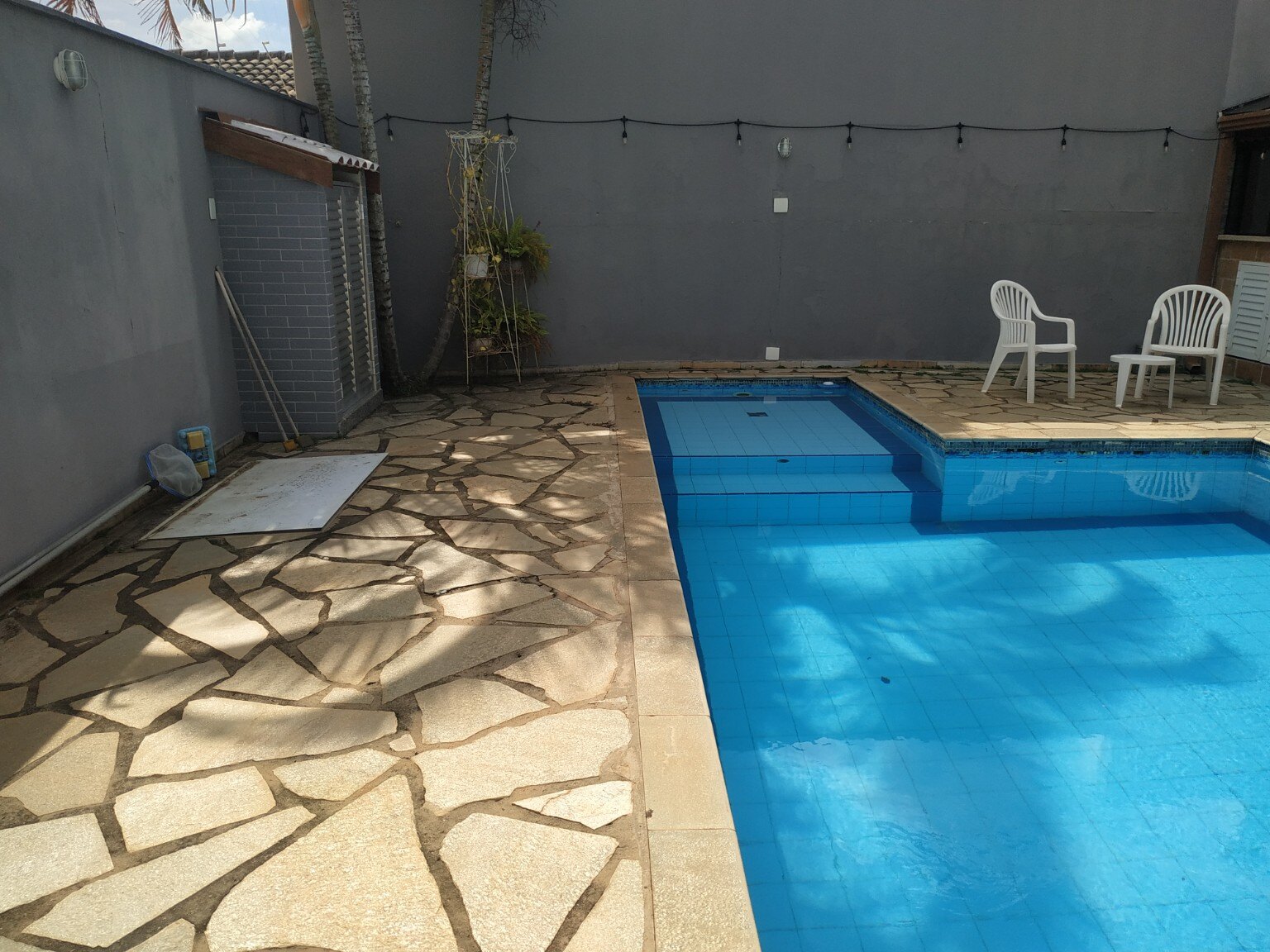Área externa e acabamento antigos da piscina